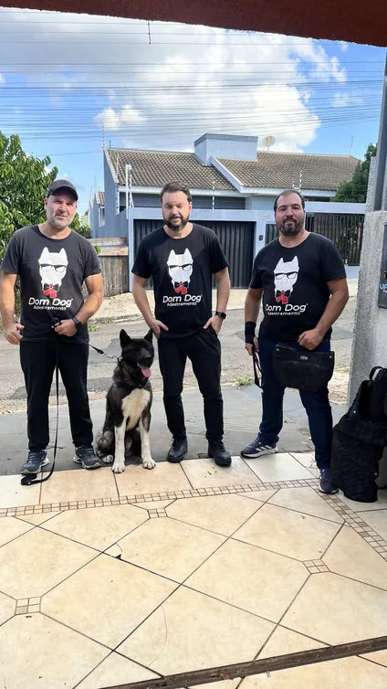 Três profissionais da DomDog com um cão em um evento