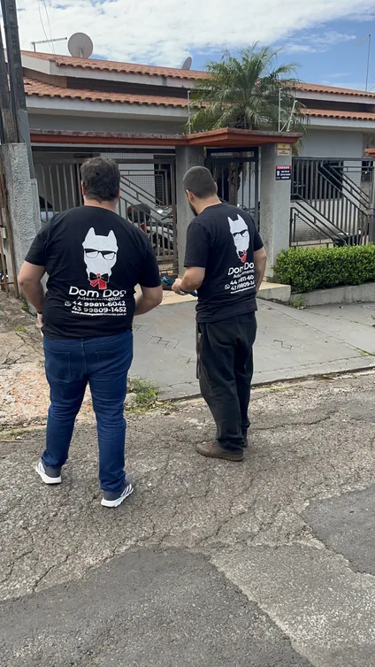 Dois profissionais da DomDog caminhando por uma rua residencial