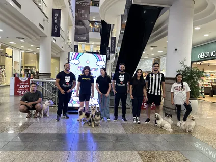 Participantes reunidos com cães em um evento no shopping